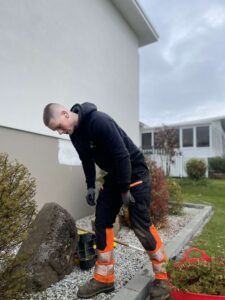 Starfsmaður Garðaþjónustu Sigurjóns að hreinsa til í beði og snyrta gróður