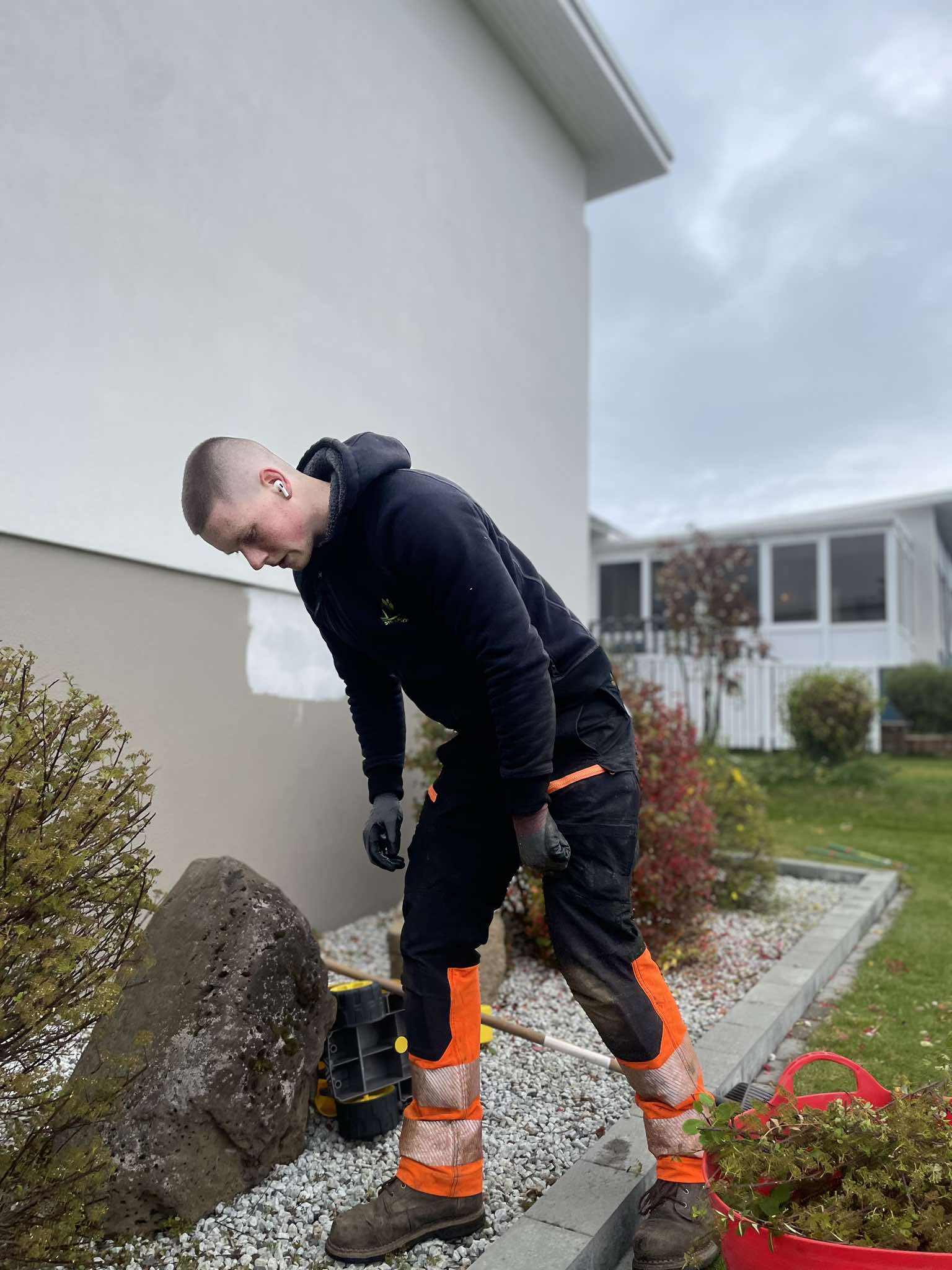 Starfsmaður Garðaþjónustu Sigurjóns að hreinsa til í beði og snyrta gróður