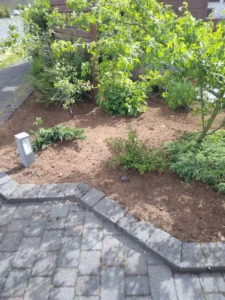 Garðahreinsun og frágangur á beði með útiljósi og grjóthleðslu.