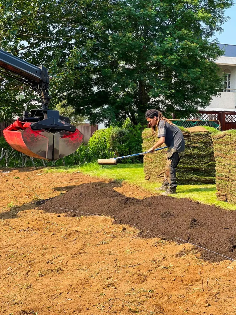 Undirvinna og þökulagning þar sem kranabíll er notaður til að hífa torfbretti.