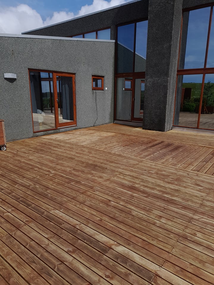 Nýhreinsaður viðarpallur sem sýnir náttúrulega fegurð viðarins