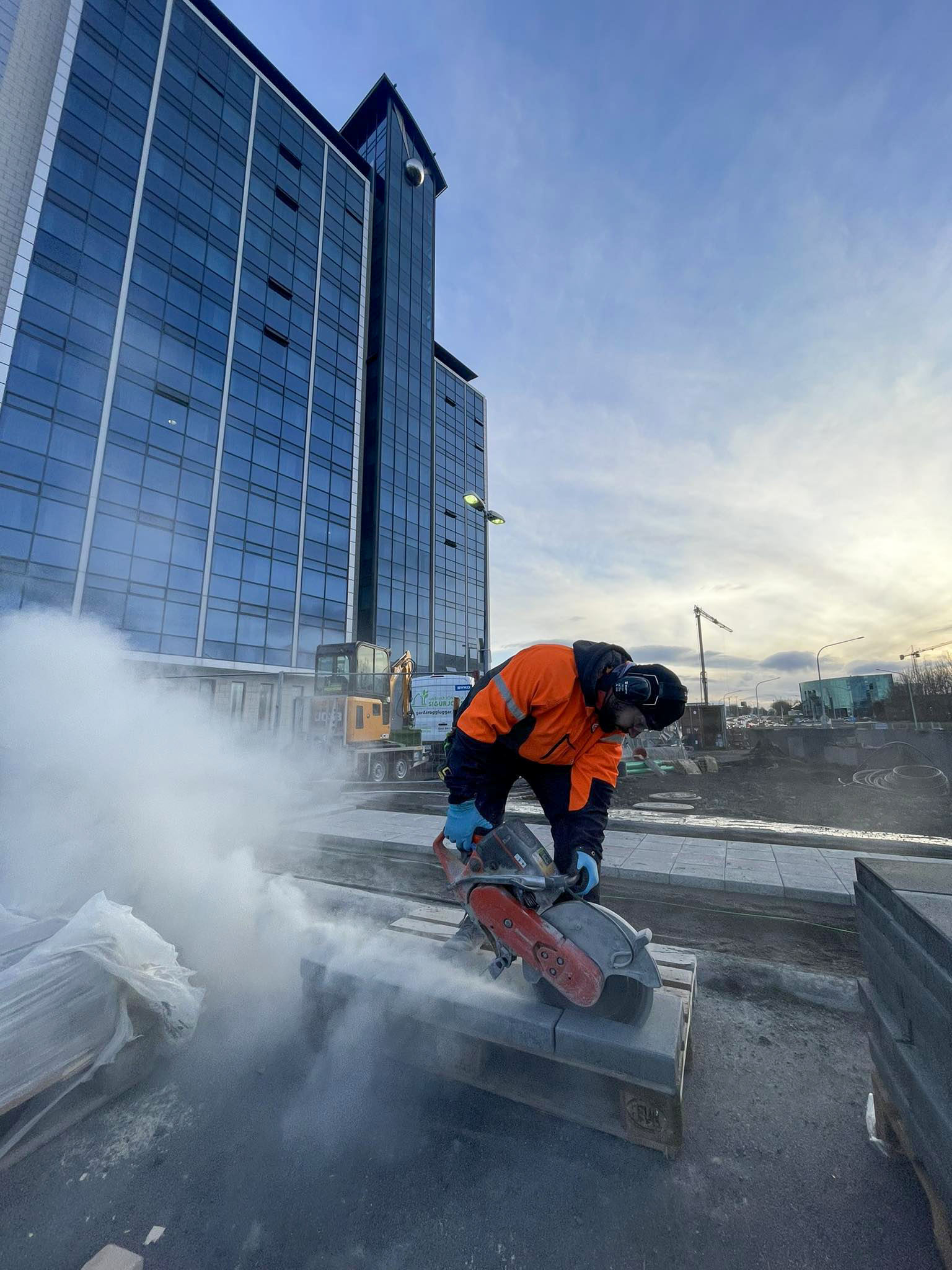 Starfsmaður Garðaþjónustu Sigurjóns að leggja hellur í bílaplan.