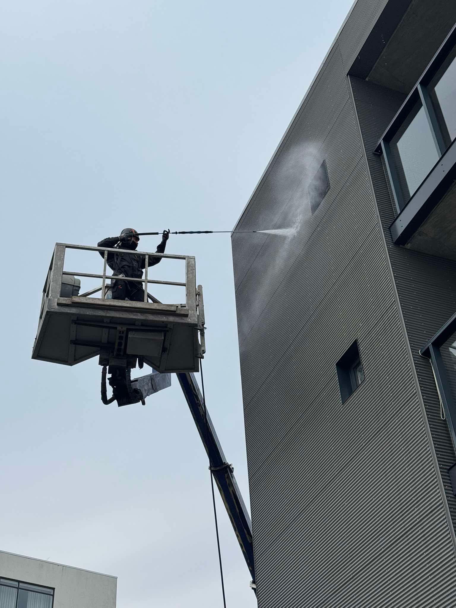 Þrif og háþrýstiþvottur á klæðningu fjölbýlishúss úr körfubíl