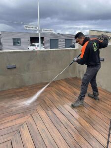 Starfsmaður Garðaþjónustu Sigurjóns að háþrýstiþvo viðarpall af fagmennsku