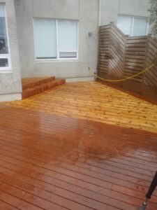 Hálfklárað verk þar sem sést greinilegur munur á nýþrifnum palli og eldri fleti